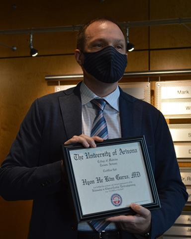 Mathew Hutchinson, MD, virtually presents certificate to Hyon He K. Garza, MD