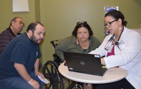 Angelica Lentner, NP, explains data captured by CardioMEMS to patient Deborah Martinez, her husband, Frank, and son, Francisco.