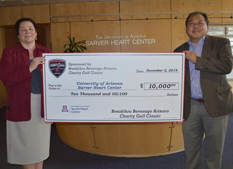 Dr. Nancy K. Sweitzer receives a check from Breakthru Beverage Arizona, with John Fung, development officer